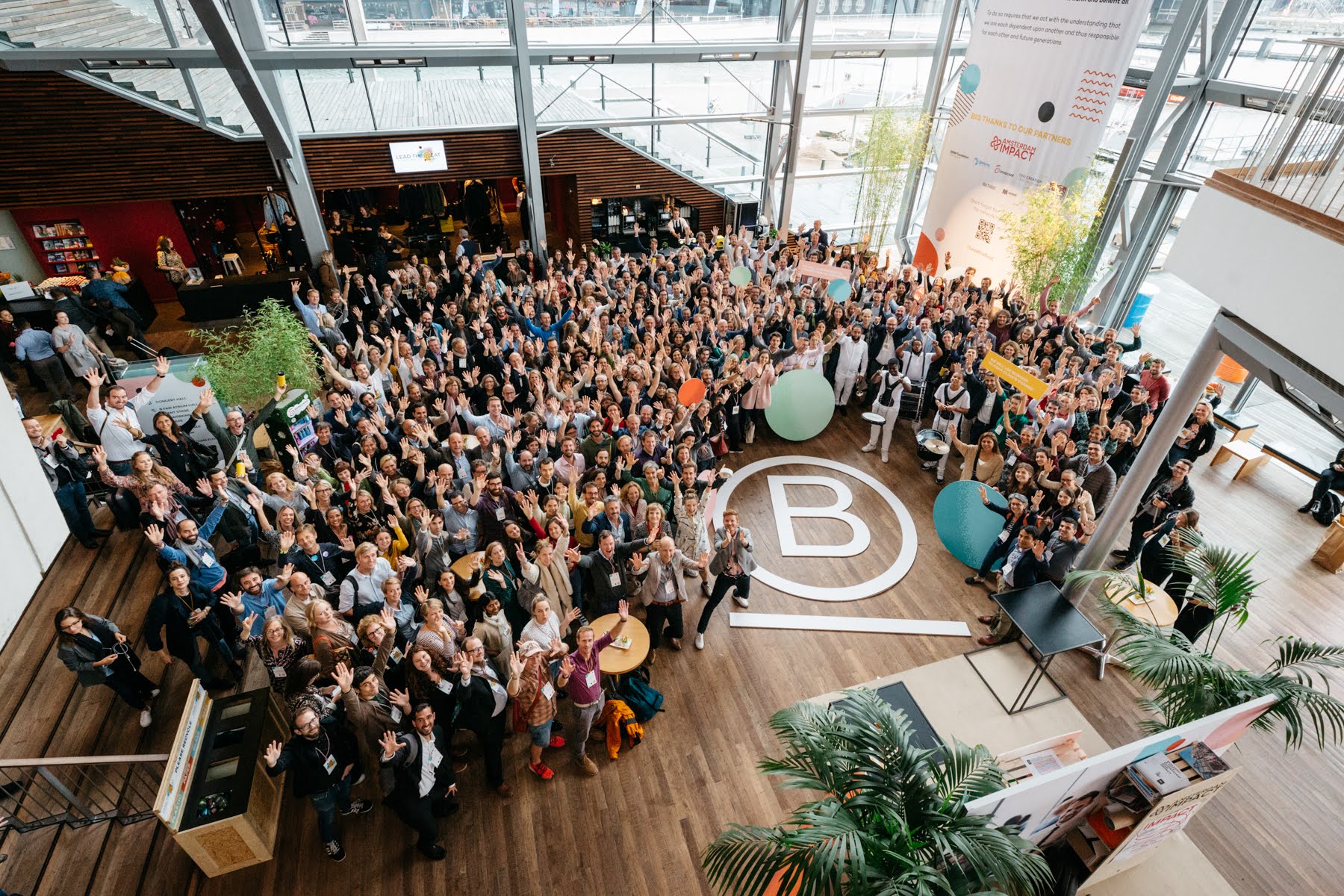 Des membres de la communauté B Corp européenne autour d’un grand logo B Corp.