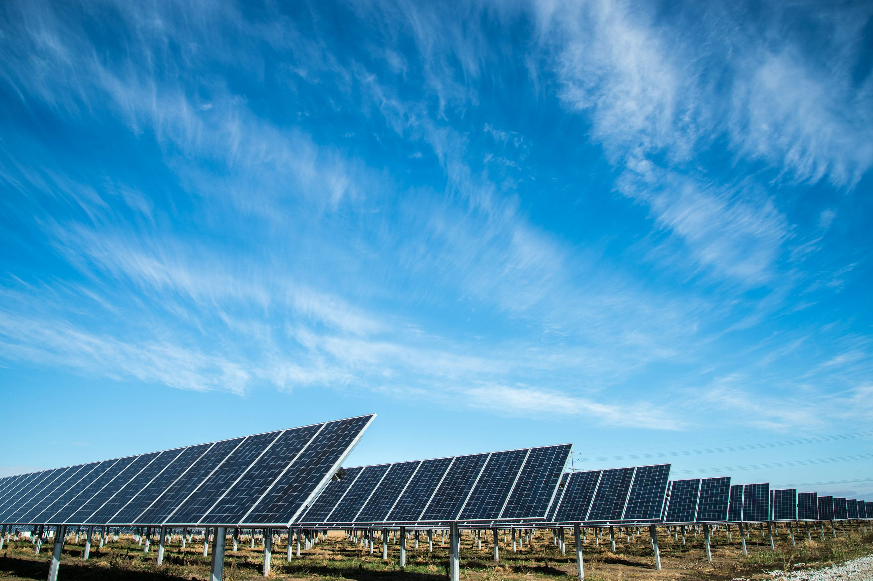 Zonnepanelen onder een heldere blauwe lucht.